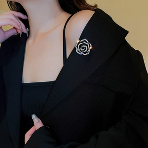 Vue détaillée d'une broche camélia en zircon avec pompons sur un revers noir