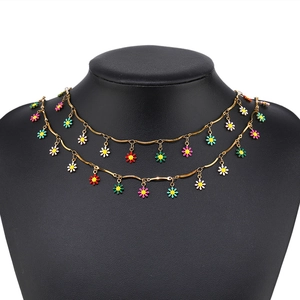 Double-layered gold necklace with colorful daisy pendants on black mannequin stand