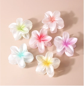 Detailed flat lay of colorful plumeria hair claws in six pearlescent pastel shades