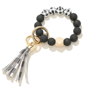 Beaded keychain bracelet with matte black silicone beads, wooden hex, and tassel charm