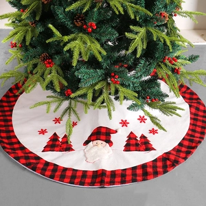 Round white fabric Christmas tree skirt with red and black buffalo plaid trim and Santa Claus