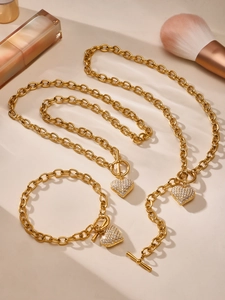 Dettaglio di un set di gioielli in acciaio placcato oro con cuore in zircone 5A