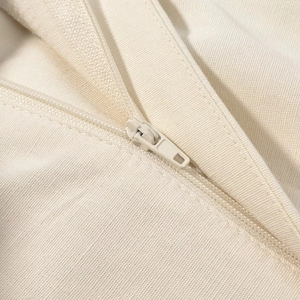 Dettaglio dei pantaloni a vita alta con cerniera tono su tono e trama della tela