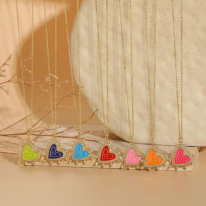 Detailed view of colorful enamel heart pendants with sparkling zircon and gold chain