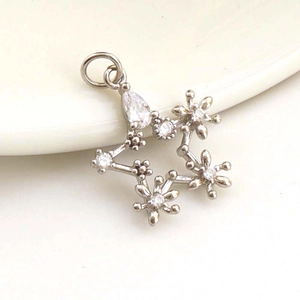 Macro shot of silver star pendant with clear zircon stones on a white ceramic plate