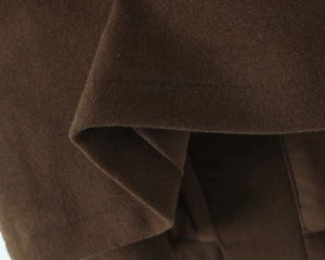 Vue macro détaillée du tissu en laine mélangée marron foncé avec coutures et doublure