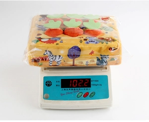Detailed view of plush carrot tissue box toy on an electronic scale weighing 102.2g
