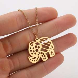 Detailed view of golden elephant pendant featuring intricate hollow patterns and textures