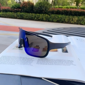 Detail of sports sunglasses with blue reflective lenses on an open magazine