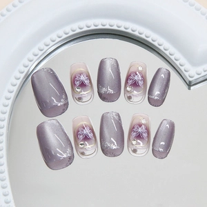 Gray-purple cat eye press-on nails with white bow designs and sparkling silver glitter