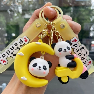 Detail of cute panda keychains with yellow moon and scooter charms on silicone straps