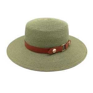 Detail view of woven straw hat featuring a flat top and stylish brown leather band