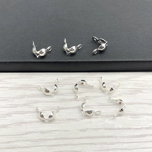 Macro view of eight stainless steel fold-over cord ends for jewelry making