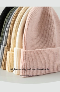 Detail der Stricktextur von Oversized-Beanies in verschiedenen Pastellfarben und weichem Stoff