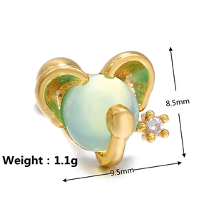 Macro view of a gold elephant stud earring with green gemstone and clear crystals