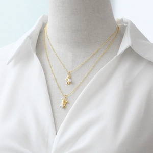 Collana dorata a due strati con ciondoli a forma di cavalluccio marino e tartaruga