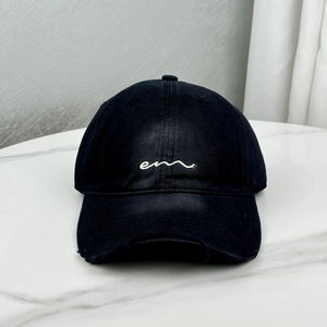Close-up of black cotton baseball cap featuring white embroidery and distressed brim details
