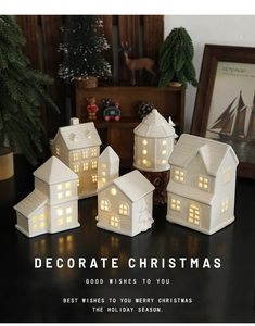Detailed view of warm LED glowing ceramic Christmas village houses with hollow windows