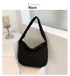 Close-up of black quilted hobo bag featuring glossy puffer material and rhombic stitching