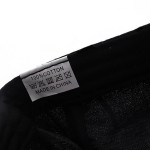 Close-up of internal wash label showing 100% cotton material on black baseball cap