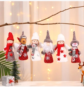 Detail of assorted plush Christmas ornaments like Santa and Snowman hanging on a branch