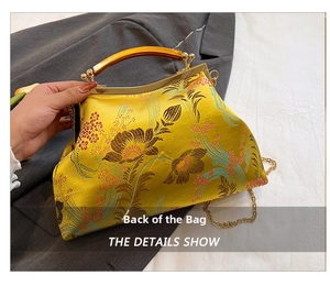 Detail view of yellow silk embroidery bag with golden floral patterns and metal handle