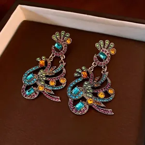 Vintage bohemian peacock flower earrings with multi-color rhinestones in a dark jewelry box