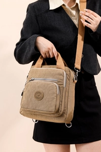 Détail du sac à langer en nylon kaki avec fermetures éclair argentées sur le mannequin