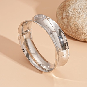 Macro shot of silver polished wide geometric cuff bracelet with spring hinge detail