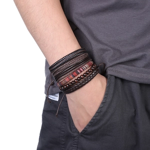 Détail de bracelets multicouches en cuir avec perles en bois et motifs tissés africains