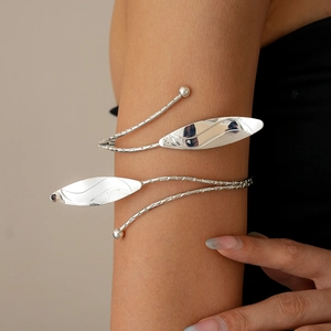 Close-up of silver metal leaf arm cuff with textured double-coil wrap design