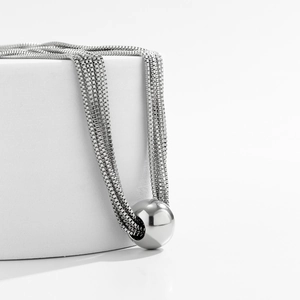 Close-up of polished silver sphere pendant on multilayered metal box chains