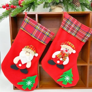 Detail of red plush Christmas stockings with Santa and snowman appliques on wood