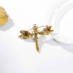 Vintage dragonfly brooch in gold alloy with green rhinestones and rear pin structure