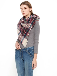 Detail of red and green plaid scarf with soft fringe edges and woven checkered pattern