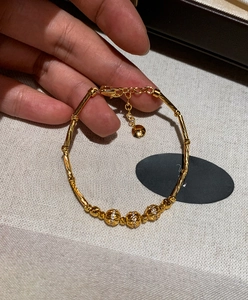 Close-up of 18K gold plated bamboo link bracelet with zircon beads and heart charm