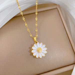 Detailed close-up of rotating daisy pendant with white enamel petals on gold ripple chain