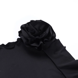 Close-up of black fabric flower decoration with layered pleats and fine fabric texture