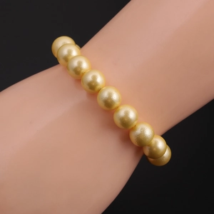 Detailed view of elegant golden pearl bracelet with radiant luster on a model wrist