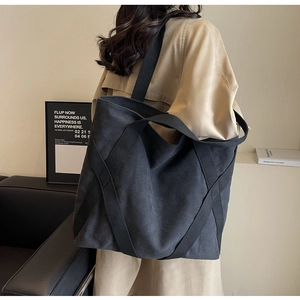 Detailed side view of black canvas tote bag with crisscross straps for student use
