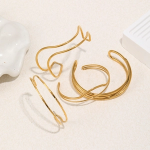 Detailed view of three 18K gold plated stainless steel bangles with twisted wavy lines