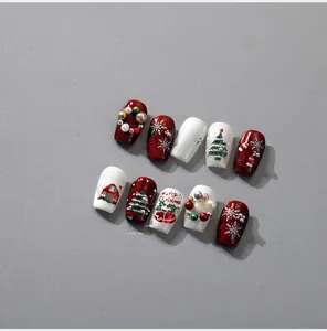 Detail of 3D Christmas press-on nails with red glitter, snowflakes and pearl accents