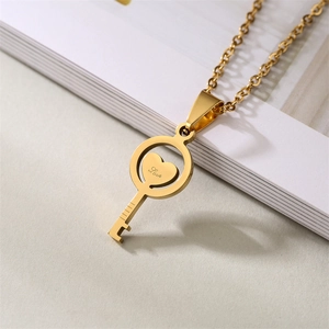 Detailed view of a gold key pendant with heart engraving Love on stainless steel chain