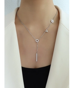 Detail of silver Y-shaped necklace with LOVE pendant and polished bar on female model