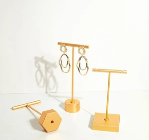 Detail view of gold matte metal jewelry display stands with t-bar and geometric bases