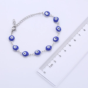 Detailed view of evil eye bracelet with metric ruler showing 1cm charms in silver and blue