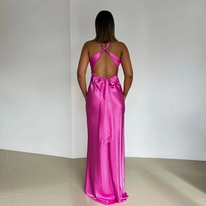Détail du dos nu élégant avec un grand nœud sur cette robe longue en satin rose fuchsia