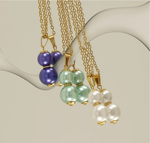 Detailed view of 18k gold plated double pearl necklaces in purple, mint green, and white