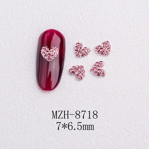 Macro shot of 3D pink heart-shaped nail art charms with micro-pave rhinestones