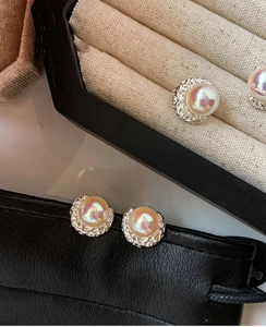 Dettaglio di orecchini vintage con perle arcobaleno e montature in argento testurizzato